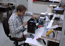 A technician re-builds a laser power supply
