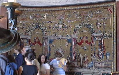 Ornate tapestries line the walls of the French room